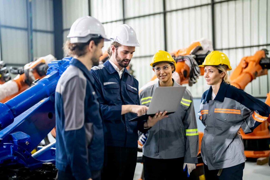 Ingegneri ed esperti di sicurezza delle informazioni eseguono auditing TISAX in un'azienda automotive.