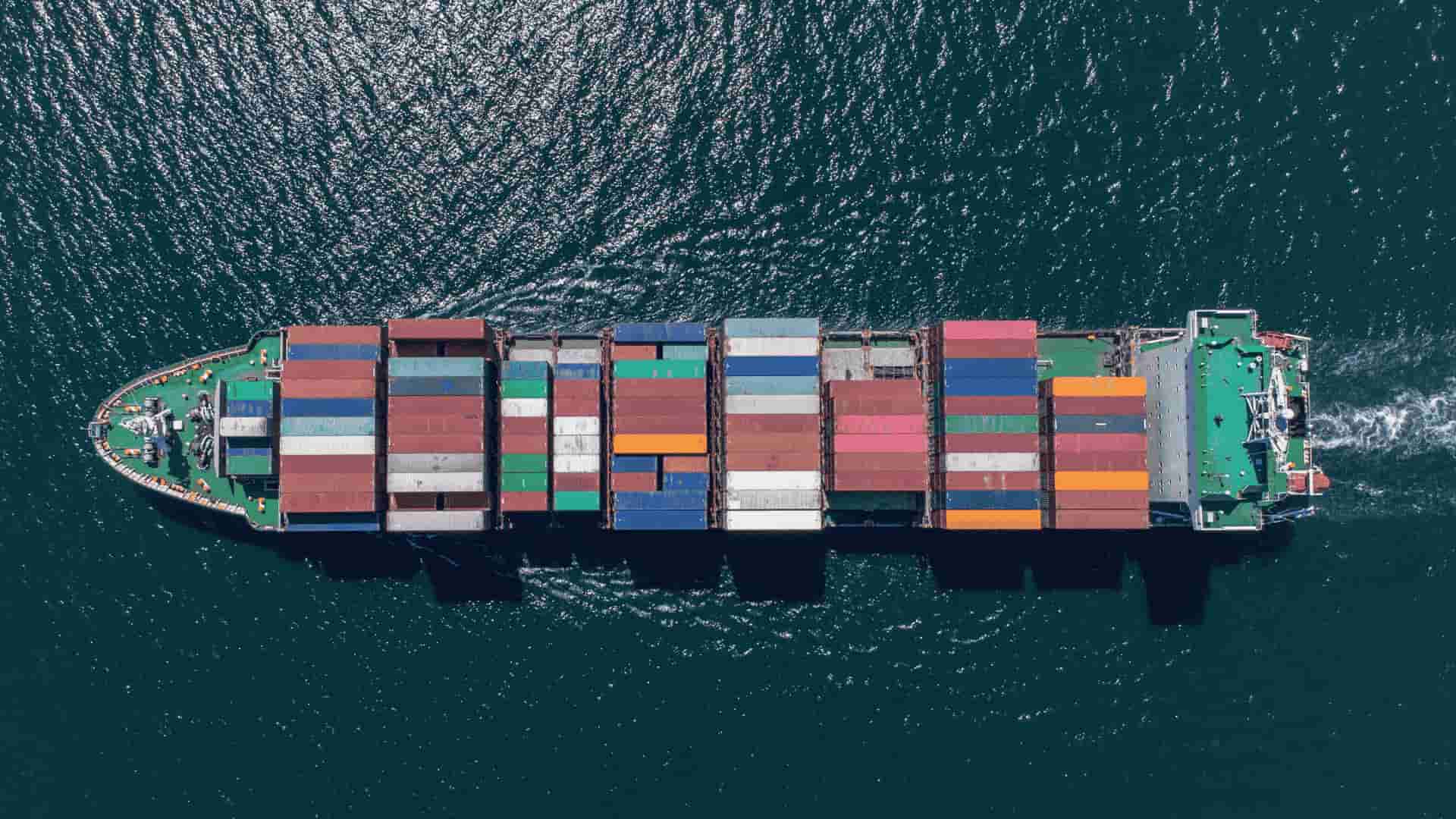Nave container vista dall'alto mentre naviga in mare aperto.