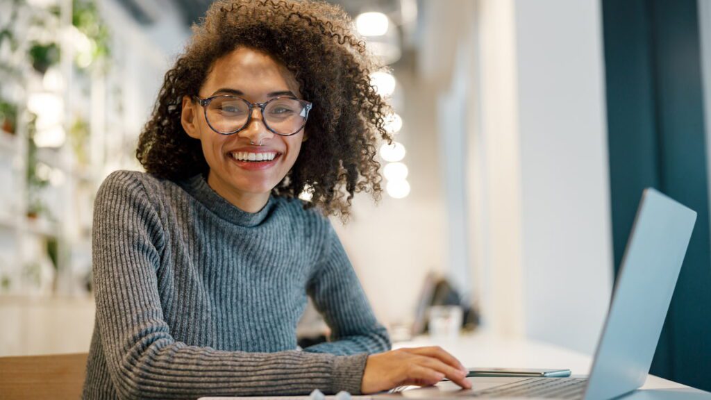 Una donna sorridente al laptot tutelata grazie al Digital Services Act.