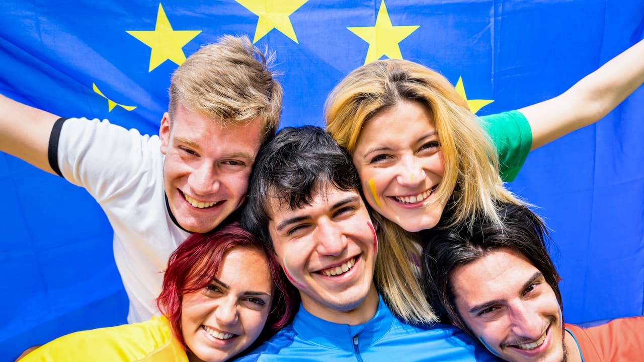 Studenti italiani con bandiera UE alle spalle, felici di partecipare a Europa=noi.