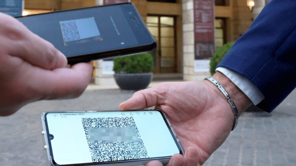 Due mani che tengono i rispettivi smartphone su cui è visibile un qrcode.