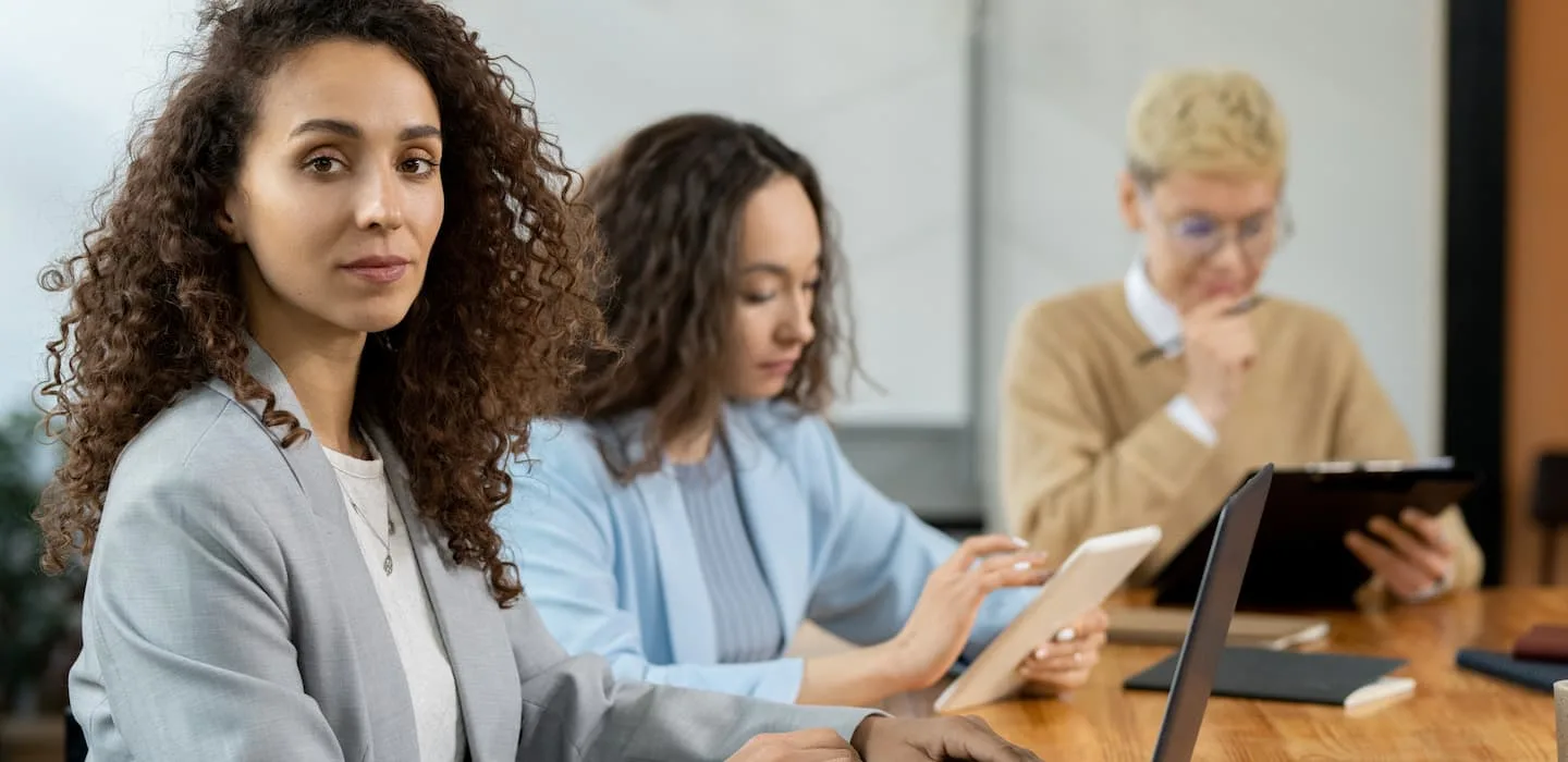 Tre persone alla scrivania con dei laptop