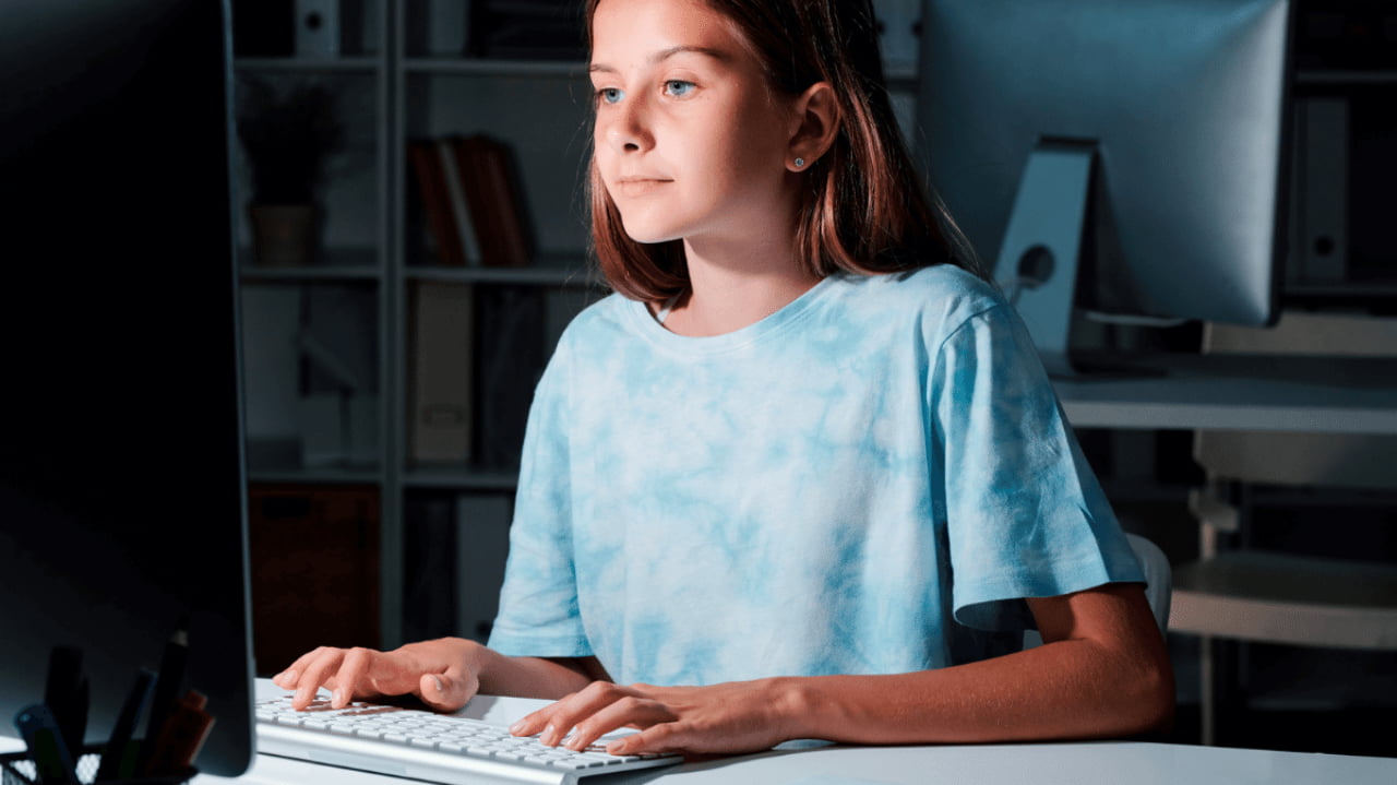 Una bambina alla scrivania davanti al PC accede ai servizi online grazie a SPID minori.